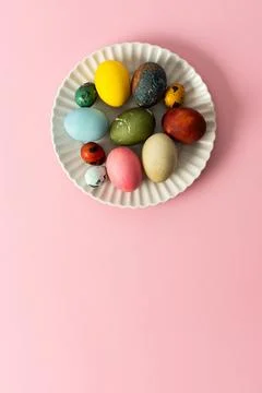 A variety of decorated Easter eggs are arranged on a circular plate against.. Stock Photos