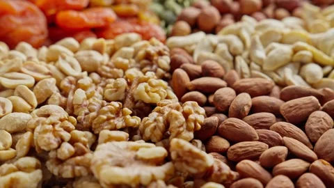 Variety of different colored raw healthy food. Nuts and dried fruits Stock Footage 302010629
