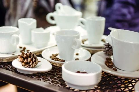 Variety of different forms of coffee cups on the metal background in exhibiti Stock Photos