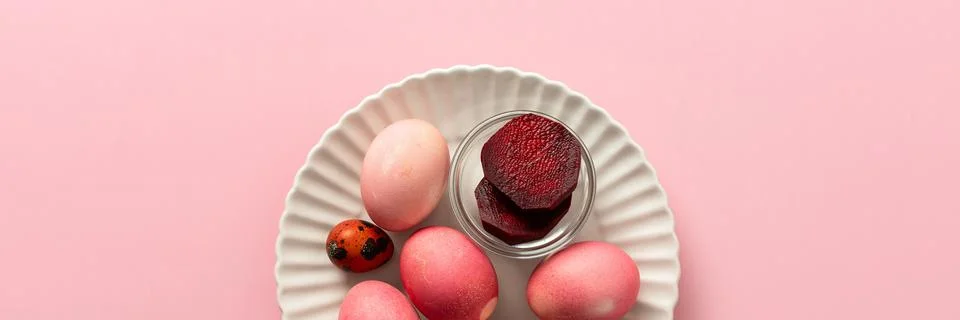 A variety of dyed Easter eggs in soft pink and vibrant shades rest on a decor Stockfoto's