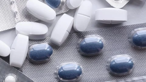 Variety of nutritional supplements rotating on surface, featuring white and blue Stock Footage 310783135