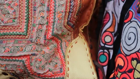 A variety of patchwork, handmade multi-colored women's bags hung at a market  Stock Footage 101876997