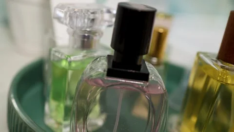 Variety of Perfume Bottles on a Circular Vanity Tray - Close-Up Luxury Vidéo 343671946