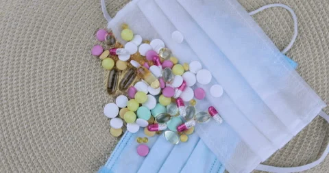 Variety of pills and tablets rotating against medical mask background Stock Footage 128644118