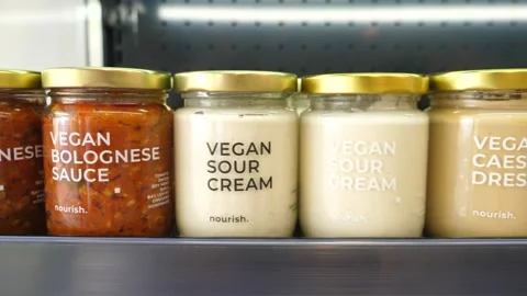 Variety of vegan dips in jars presented on a display in organic store. Plant Video stock 147438933