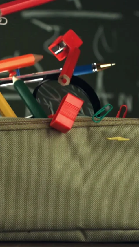 Various accessories fall into the school pencil case. Filmed on a high-speed Stock Footage 335375338