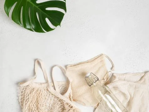 Various bags with drawstring, string bag and glass bottle flat lay Stock Photos