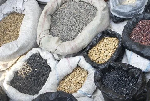 Various beans and seeds in plastic bags display at street market photo. Stock Photos
