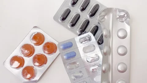 Various blister packs of medication, including capsules and tablets, emptyi.. Vídeos de archivo 335141609
