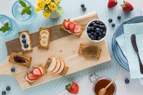 Various breakfast crackers with fruit and spread toppings and copy space. Stock Photos