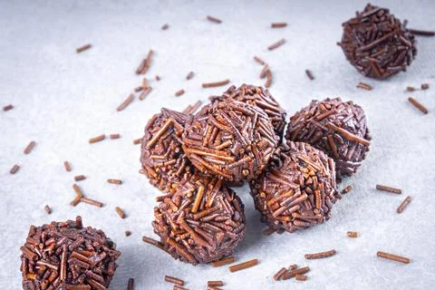 Various "brigadeiro" sweets on a white table with chocolate sprinkles lying.. Stock Photos
