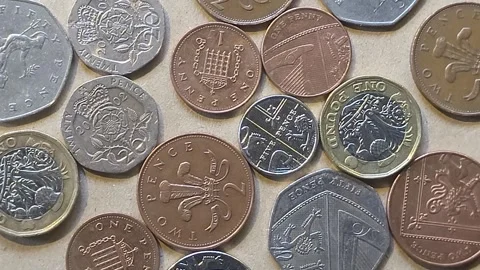 Various British coins on brown background rotate Stock Footage 245825947