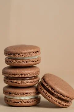 Various brown macarons on a brown background Stock Photos