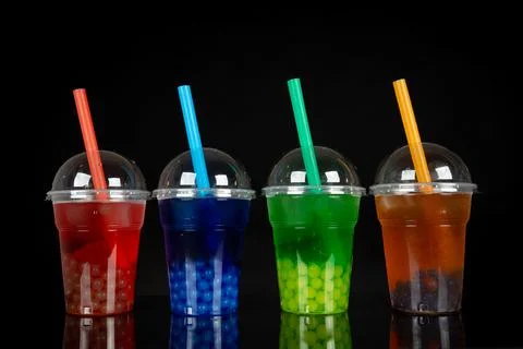 Various Bubble Tea in a plastic cups with drink straws on black background. T Stock Photos