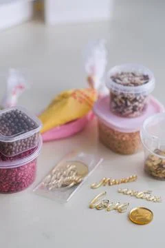 Various cake decorating supplies including sprinkles, nuts, and golden letter Stock Photos