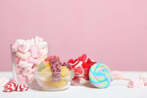 Various candy and sweets on the table on a colored background. Stockfoto's