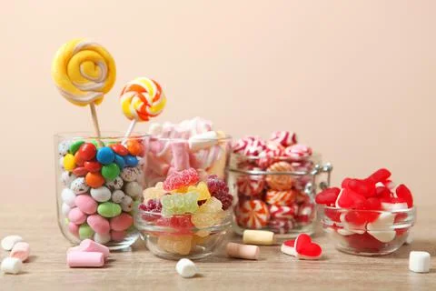 Various candy and sweets on the table on a colored background. Stock-Fotos
