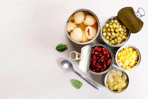 Various canned vegetables on kitchen table background. Photos