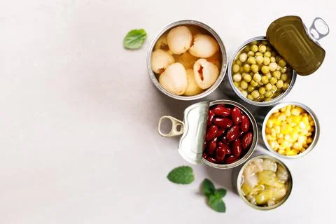 Various canned vegetables on kitchen table background. Foto stock