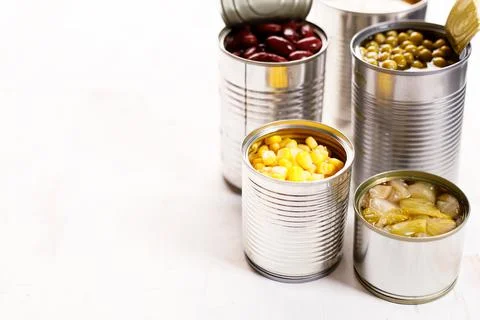 Various canned vegetables on kitchen table background. Photos