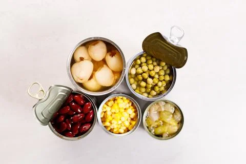 Various canned vegetables on kitchen table background. Photos