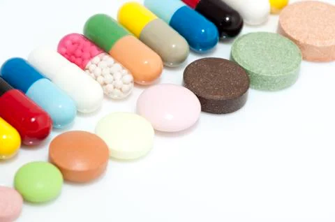 Various capsules and tablets in row Stock Photos