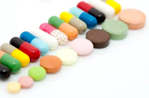 Various capsules and tablets in row Stock Photos