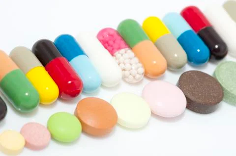 Various capsules and tablets in row Stock Photos