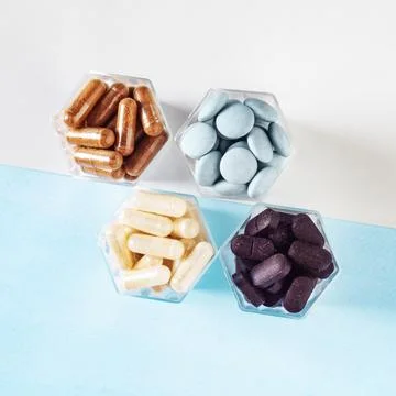 Various capsules with dietary supplements or medicines in honeycomb form jars Stock Photos