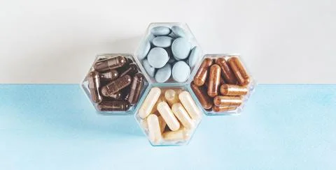 Various capsules with dietary supplements or medicines in honeycomb form jars Stock Photos
