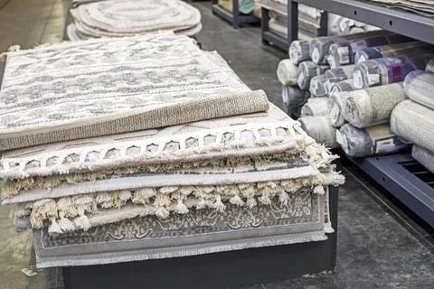 Various carpet samples with textures and patterns on the table and shelves Stock Photos