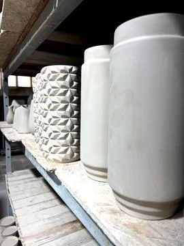 Various ceramic items are displayed on shelves in a pottery studio, highlig.. Stock Photos