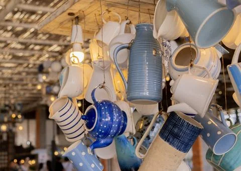 Various ceramic items hang from the ceiling in a restaurant. Restaurant int.. Stock Photos