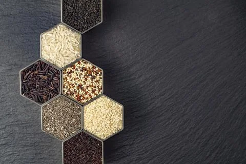 Various cereals and grains in the hexagonal shaped honeycomb jars Stock Photos