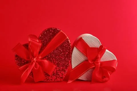 Various choices gift box in the form of heart with a red ribbon on a red back Stock Photos
