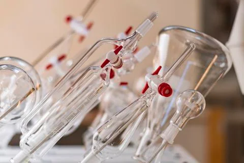 Various clean glssware hanging on the wall in a chemistry laboratory for biot Stock Photos