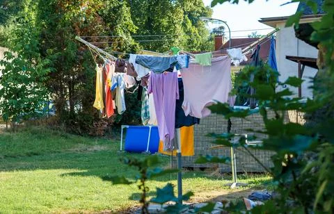 Various clothes drying outside after washing on an umbrella dryer Stock Photos