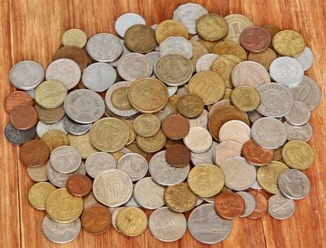 Various coins of different countries of world on wooden background. Stock Photos