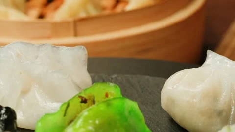 Various of colored dim sum on black plate close-up macro. Steaming Technique Stock Footage 257591187