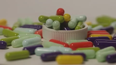 Various colored medicine capsules on a circular pedestal Stock Footage 250489029