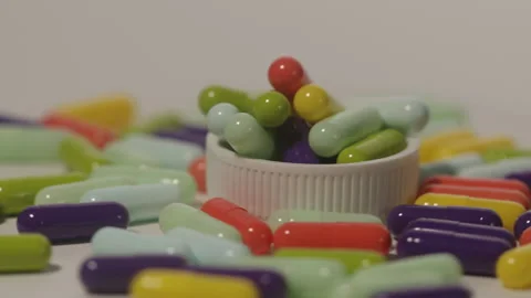 Various colored medicine capsules on a circular pedestal Stock Footage 250489120