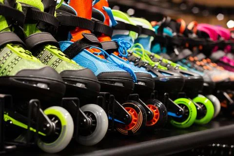 Various colored roller skates standing on shelf. Stock Photos