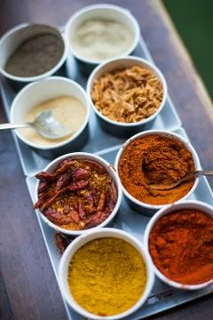 Various colored spices in recipients Stock Photos