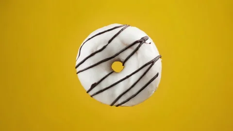 Various colorful donuts. Different donuts changing at yellow background Video stock 160189365