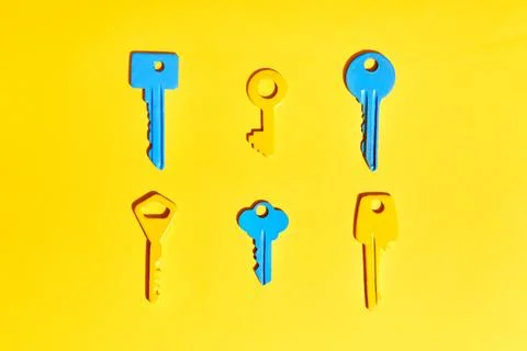Various colorful keys on vibrant yellow background Stock-Fotos