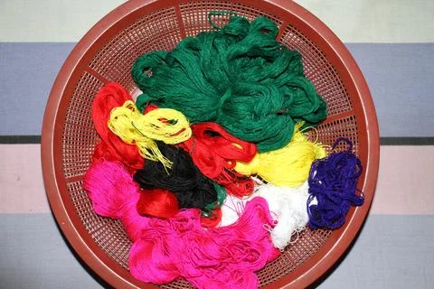 Various colorful threads and wool are in the bowl. Stock Photos