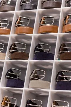 Various coloured leather belt display on shelf in the store in a men clothing Stock Photos