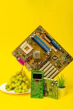 Various computer boards with grapes on a yellow background 库存照片