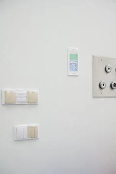 Various Control Panels and Electrical Switches on a White Wall in hospital Stock Photos