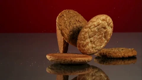 Various cookies falling onto dark reflective surface Stock Footage 327052337
